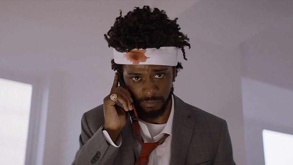 
Dans Sorry to bother you, le personnage interprété par Lakeith Stanfield adopte une « voix de blanc » pour devenir un « supervendeur ». on le voit au téléphone, et il a un bandage sur la tête.