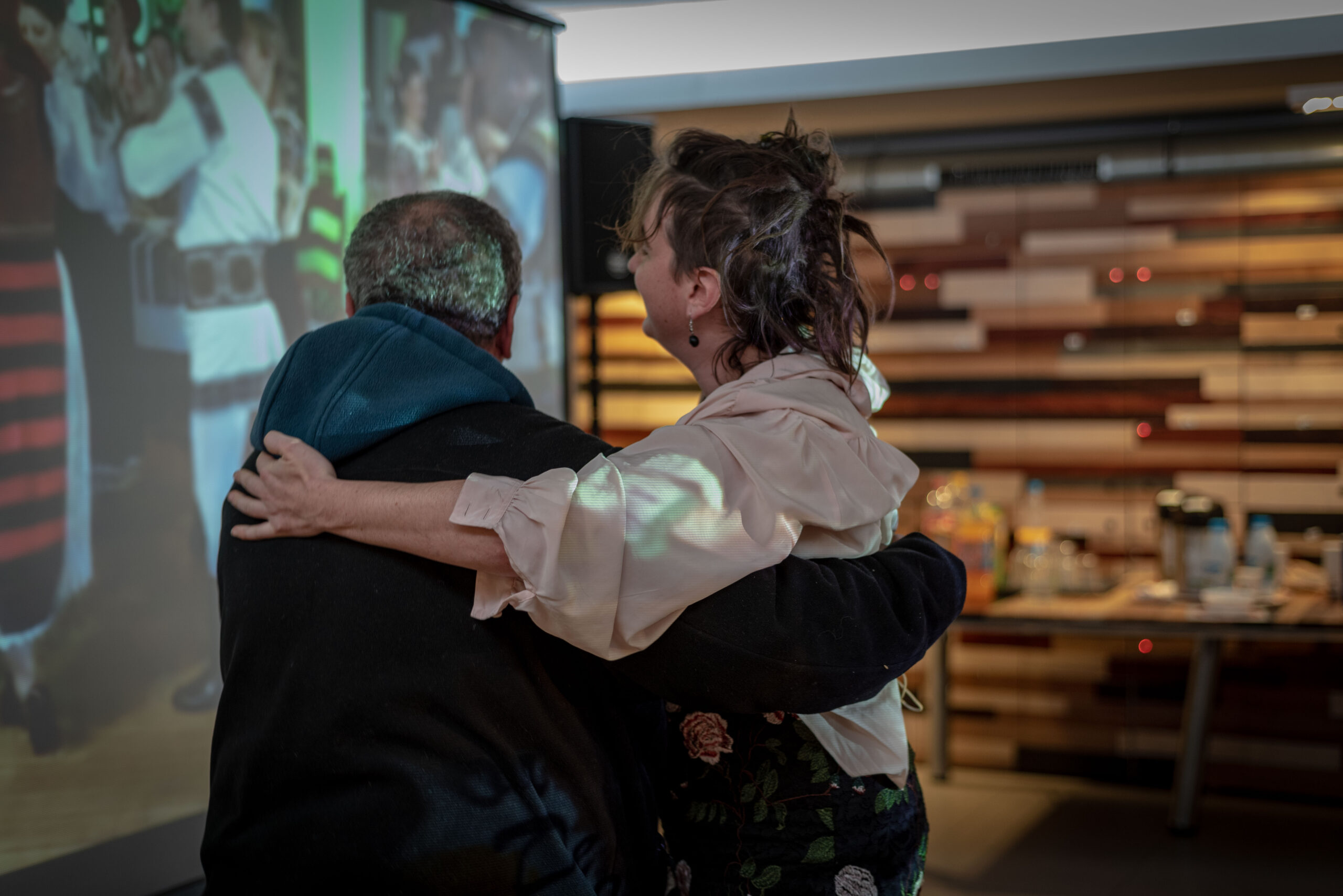 Cette photo montre deux personnes en train de danser, lors d'une projection chez Douche Flux.