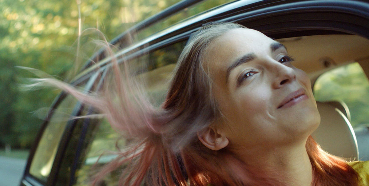 Une image du film Lola vers la mer : le personnage principal passe la tête par la fenêtre de la voiture.
