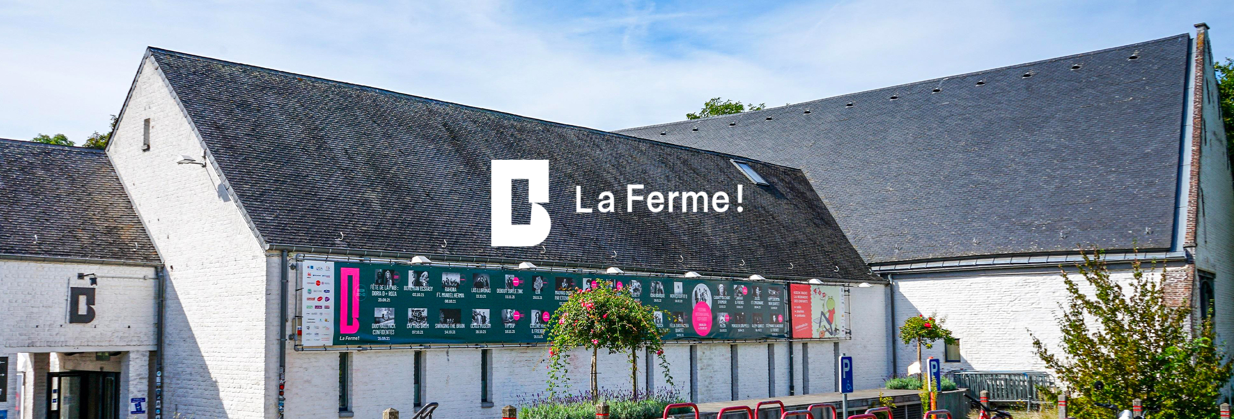 Bâtiment de La Ferme! avec logo et affiches culturelles.